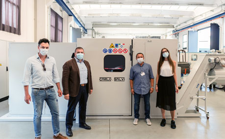 A group of four people wearing face masks standing next to new Carlo Salvi machine